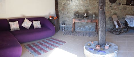 lounge with large purple coach and antiques, vintage vases, Hi fi and turntable
