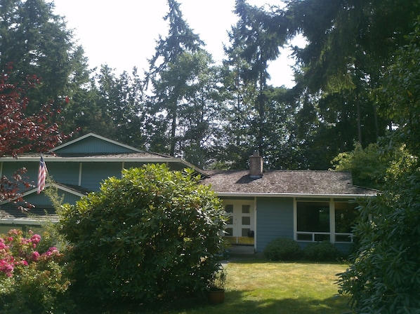 The home is located on a quiet street with a forested area on the side street.