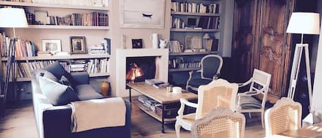 Salon avec cheminée et bibliothèque
