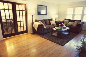 Living room w/ French doors (open) to dining room & kitchen