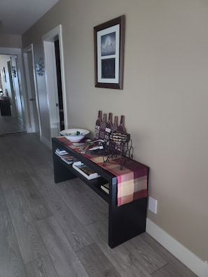 Side table holds large fruit bowl, large spoons, bottle opener.