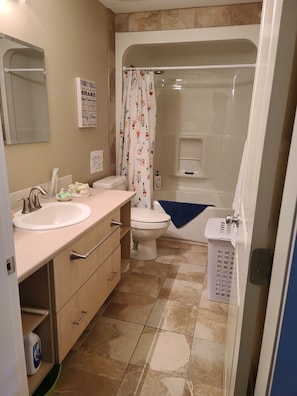 Bathroom with full tub/ shower, sink, toilet. Towels (drawer), toiletries, etc.