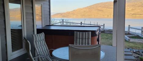 Patio table and chairs beside hot tub.