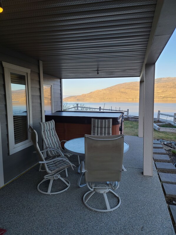 Patio table and chairs beside hot tub.