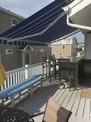 outside deck with retractable awning and bar with 42 inch flat screen