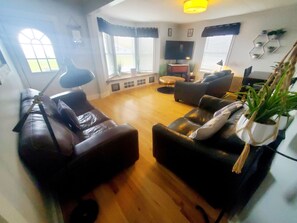 Large open concept living room/kitchen w/ three leather couches 