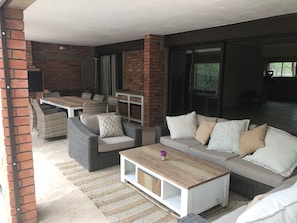Comfortable patio area with barbecue facilities and boma. Looking onto pool. 