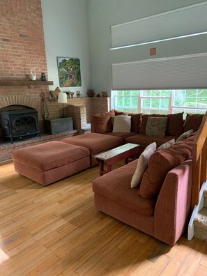 Cozy living room with cathedral ceilings and oversized playpen sofa.