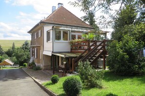 Villa von hinten. Der Eingang zur Ferieneohnung ist unterhalb des Wintergartens