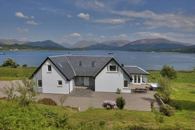 Luxury waterfront property with outdoor hot tub on shore of Scottish sea Loch.