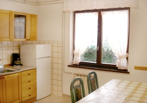 La cucina abitabile doaa di frigorifero con area congelatore e tavolo da pranzo 