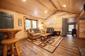 Open living room with sofa, recliner,  smart TV, gas fireplace, table w. chairs