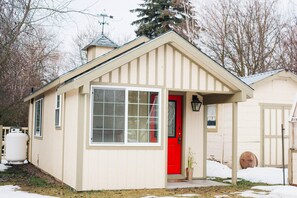 Charming cottage with kitchen, bathroom, murphy bed, and porch.