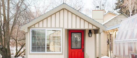 Charming cottage with kitchen, bathroom, murphy bed, and porch.