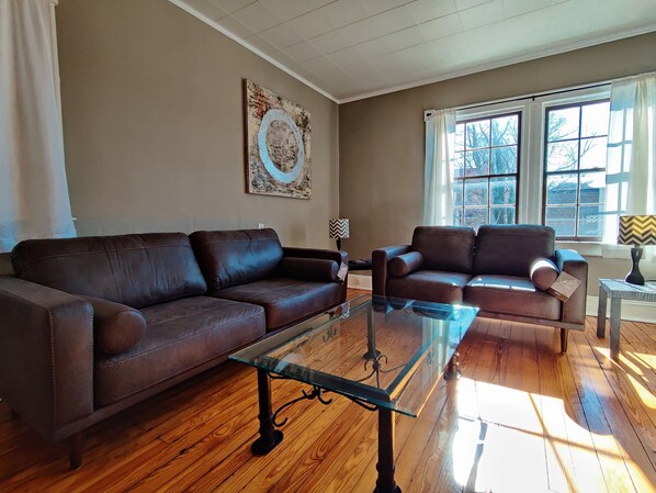 Living room with new couch and loveseat set, and wall mounted LED TV