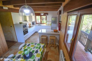 Vista general de la cocina, con mesa comedor, isleta central y zonas de trabajo.