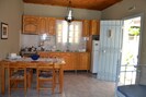 Kitchen zone offers dining table, refrigerator, stove, sink. Kefalonia bungalows