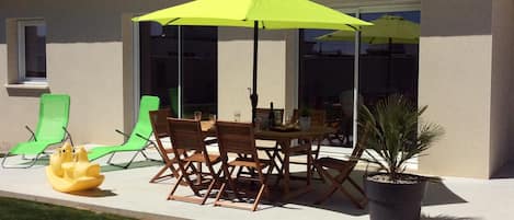 La terrasse de la maison avec ses deux baies qui donnent sur le jardin clos 