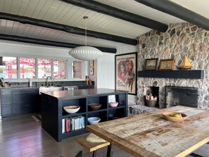 kitchen with stone fireplace and views of the garden and lake