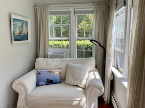 The loveseat in the main bedroom is a place to snuggle, read, or just relax