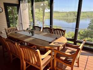 Screened in porch overlooking the lake with built in gas grill and dining set