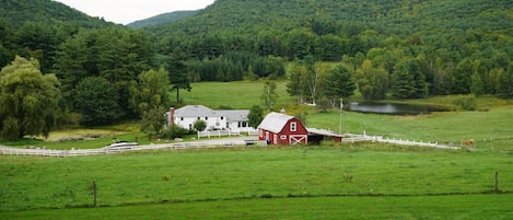 Hidden Valley Farm. White farm house, red barn, pond.
