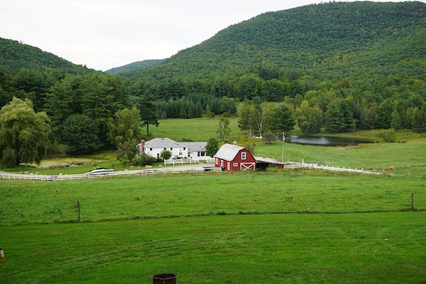 Hidden Valley Farm. White farm house, red barn, pond.
