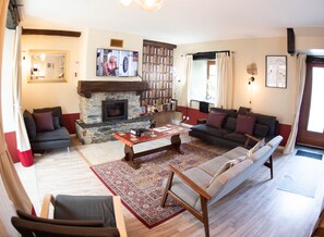 Living room with log fire and wall heater.
