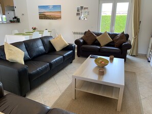 Casa Bela - Leather sofas with dining table behind