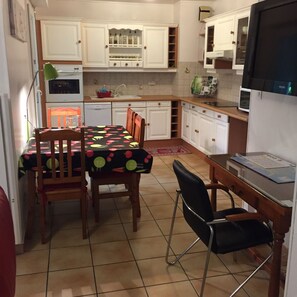 vue de la cuisine ouverte
avec un espace bureau sous le grand écran TV