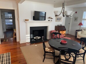 Dining/living room with TV. Fireplace is not functional. Main bath door to right