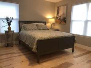 Comfy queen sized bed in master bathroom. Workspace in corner.