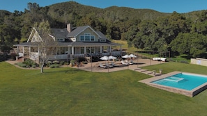 Back of Ranch House with pool, terrace, entertaining areas, and sweeping views. 