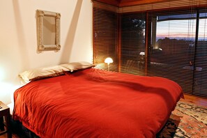 This cosy second bedroom features a queen bed and shutters to ensure a peaceful night's sleep.