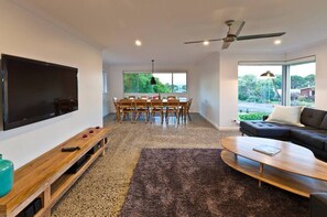 Relax in the light-filled lounge with a plush sectional sofa, flat-screen TV, wood-burning fireplace and ceiling fan—perfect for year-round comfort.