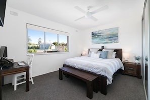 Main bedroom with king size bed, desk, monitor and laptop stand