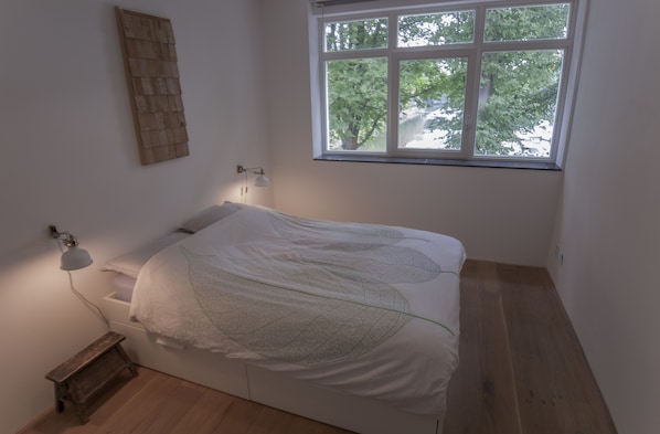 Bedroom overviewing the lake's harbour. Real down comforter and 100% nat. linnen