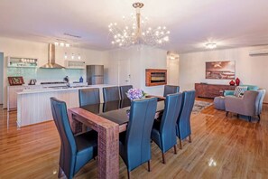 Gather around the large dining table beneath a beautiful chandelier for meals and catch-ups.