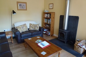 Open plan sitting room with woodburner