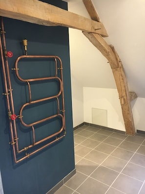 La salle de bain et son radiateur en cuivre