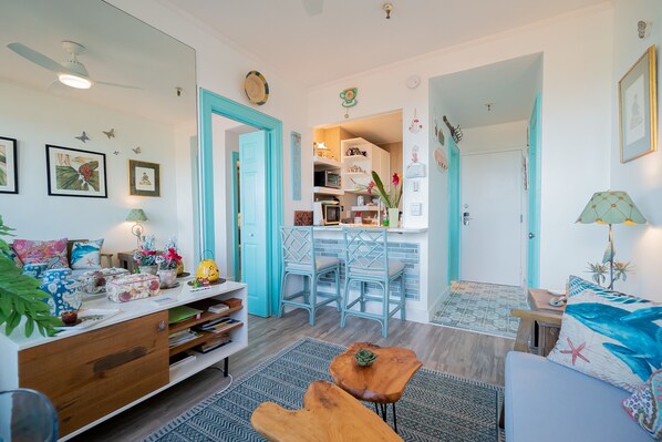 Living room looking at entrance and kitchenette.