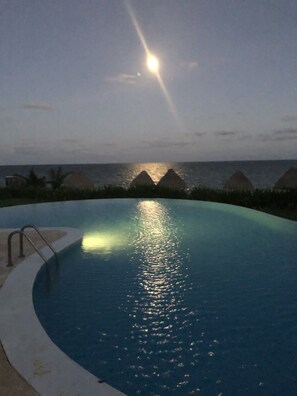 Moon rising over ocean an pool