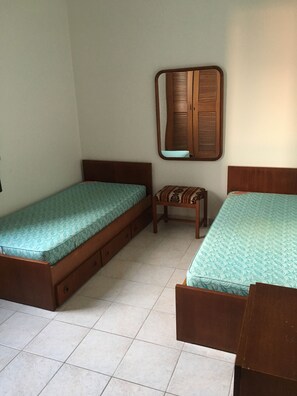 Quarto solteiro com espelho e armários com prateleiras e cabides 