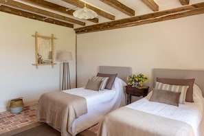 A second floor bedroom with three beds, en-suite, and fresh linens