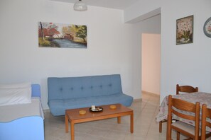 The living room offers a kitchen area, dining table, 2 sofas and coffee table