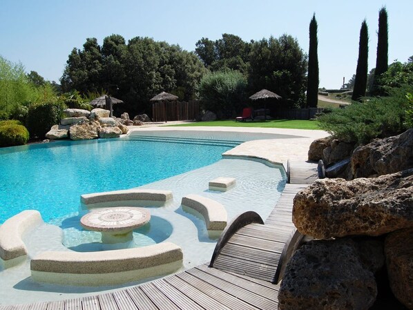 Piscine immergée à débordement avec gazon synthétique