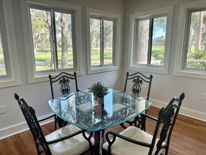 Sunroom with table and chairs and views of Cougar Point Golf Course.