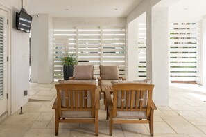Covered Patio with TV and Chairs.