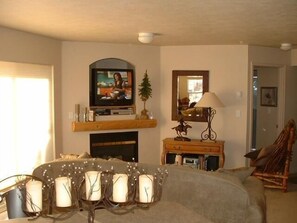 Living area w/ pullout sofa, gas fireplace, flat screen Sat/TV and balcony.