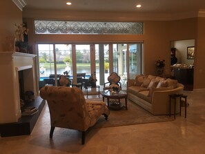 Luxurious living room with gorgeous view of lanai area, pool and lake